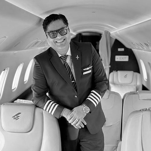 Man in light shirt with arms crossed on white background