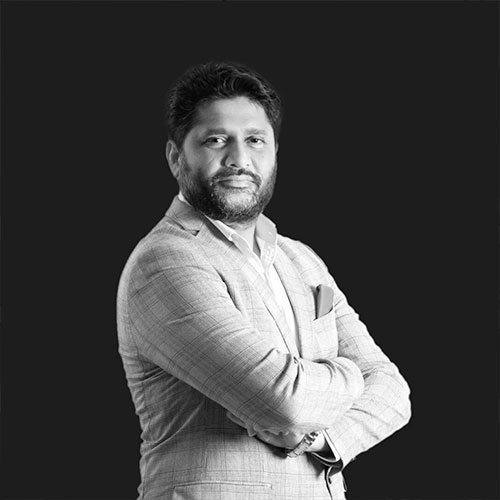 Man in light shirt with arms crossed on white background